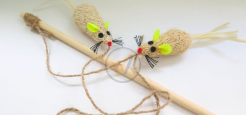 Two loofah fibre mouse toys with felt ears tied to a wooden cat wand